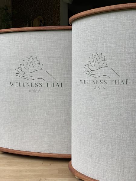 Les 2 banques d'accueil pour le Wellness Thaï & Spa en forme d'ellipse. Le logo est une sérigraphié sur le tissu qui les habille. 