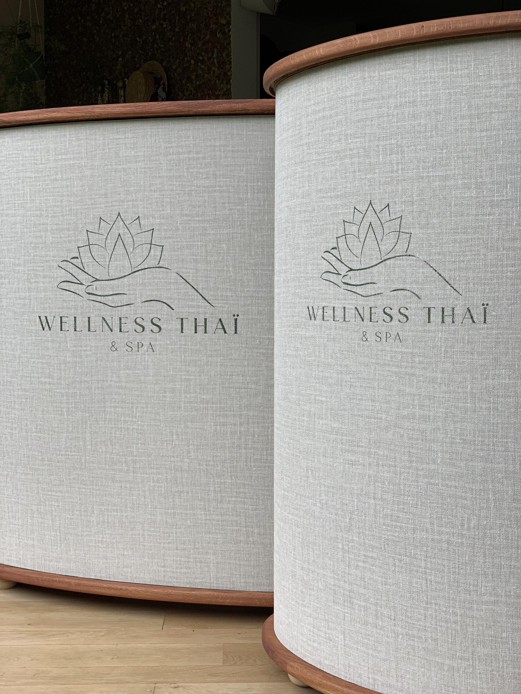 Les 2 banques d'accueil pour le Wellness Thaï & Spa en forme d'ellipse. Le logo est une sérigraphié sur le tissu qui les habille. 